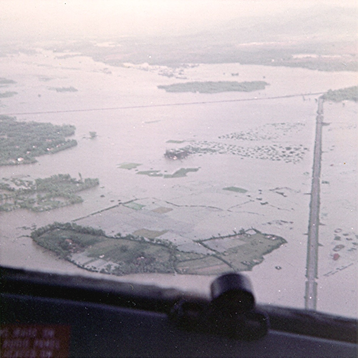 1968, October, Da Nang, Vietnam under flood waters as seen from the camera of Pan Am Flight Attendant, Maureen van Leeuwen while on a US troop transport flight in support of the Vietnam War effort.